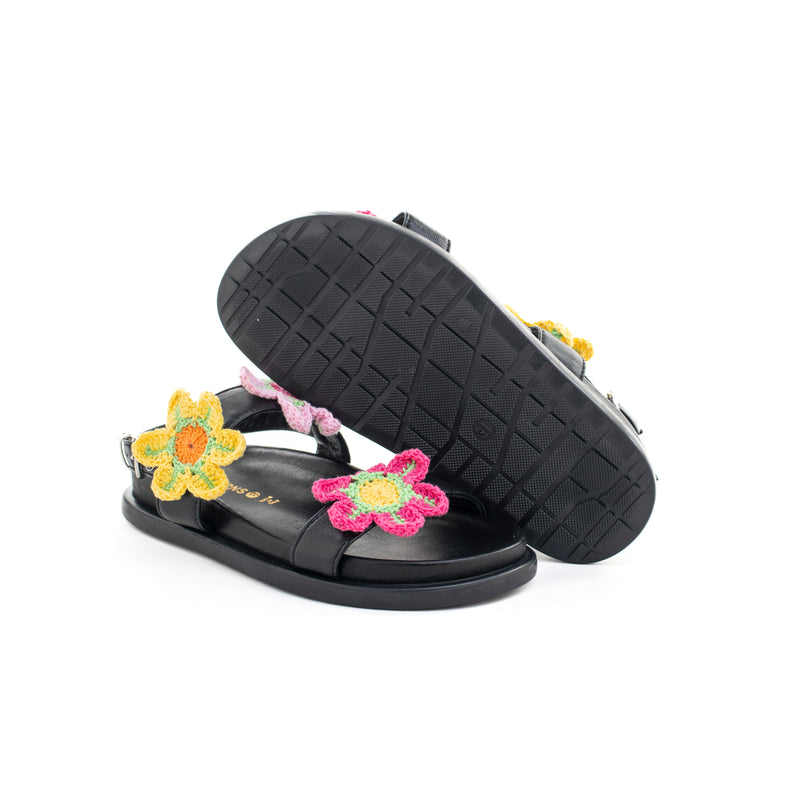 Sandalo in nappa nero con fiori a maglia colorati applicati. Chiusura con cinturino regolabile.