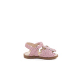 Sandalo ricoperto da una sottile pioggia di glitter color rosa. Super brillante con elementi floreali laterali. Chiusura a strap regolabile.