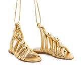 Sandalo in pelle color oro con intreccio sul fronte. Allacciatura alla caviglia. Artigianale e Made in Italy.