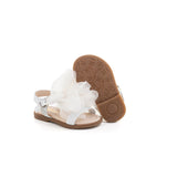 Sandalo in nappa bianco con un fiore bianco ton sur ton. Chiusura con cinturino regolabile.