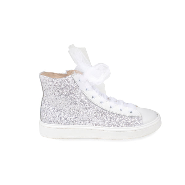 Sneaker alta in pelle, ricoperta da una pioggia di glitter bianco. Lacci in tulle e zip laterale.