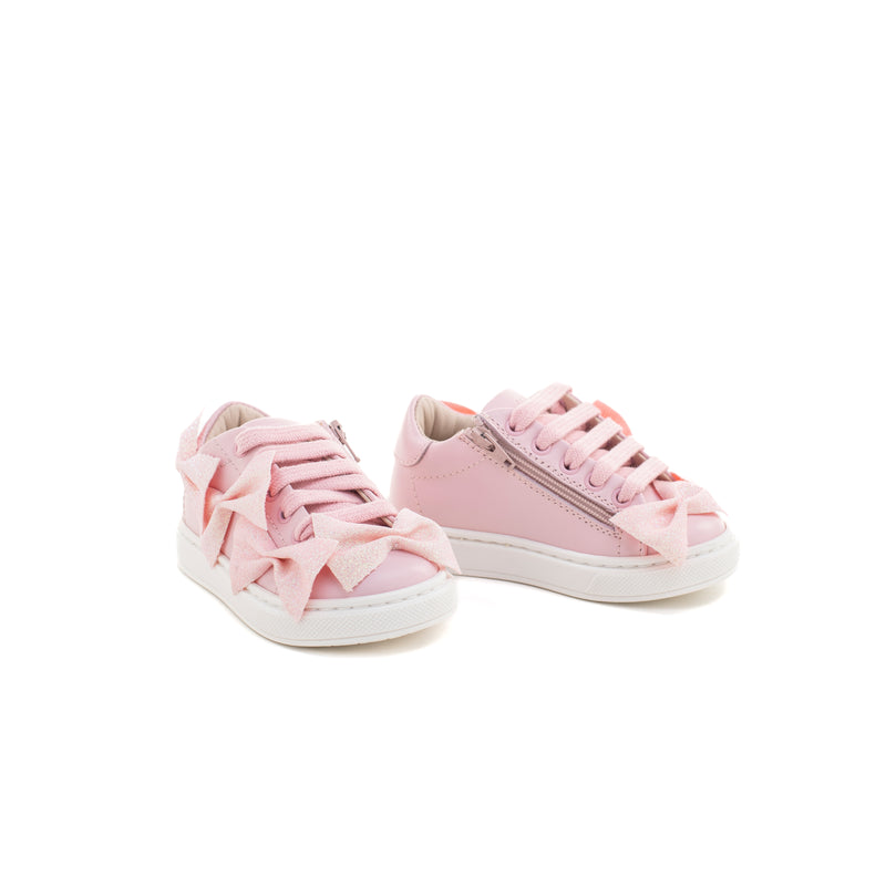 Sneakers in pelle rosa impreziosita da piccoli fiocchetti glitterati ton sur ton. Chiusura con lacci. Artigianale e Made in Italy.