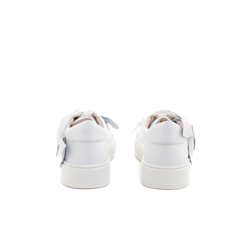Sneakers in pelle bianca impreziosita da piccoli fiocchetti ton sur ton. Chiusura con lacci. Artigianale e Made in Italy.
