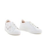 Sneaker bianca con stelle di glitter beige. Modello trendy per la primavera estate 2023.