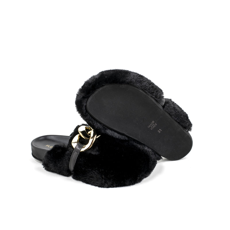 Slipper in pelliccia nera con catena d’oro sul fronte.