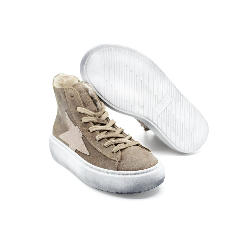Sneakers alte in pelle scamosciata color taupe beige, con interno in montone e stella sul lato. Suola in gomma a contrasto bianca effetto invecchiato, zip laterale e lacci.