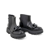 Stivaletto in pelle nera con catena ton sur ton. Suola in gomma e zip laterale.